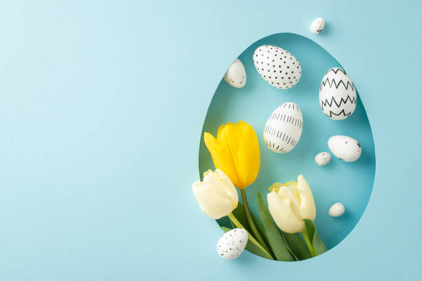 Lovely Easter imaginative idea. Top view perspective of fresh tulips and eggs, seen through an egg contour on a pastel blue background, providing space for unique greetings or adverts
