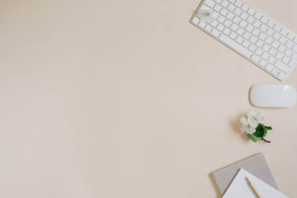 istock Workspace with a computer, white flowers and stationery on a pastel beige background. Distance work, online learning concept with place for text. 2075750273