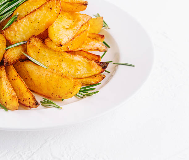 istock Baked potato wedges with rosemary on plate 2075752038