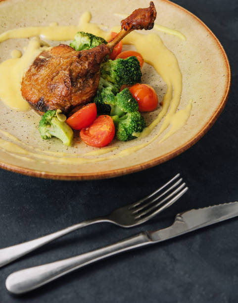 istock Confit duck leg with broccoli and tomatoes 2075754103