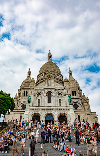 Paris, France - July 23 2022: Sacre Coeur at the top of Montmarte Hill with crowded tourists.