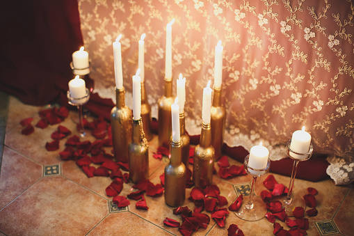 Candle in the bottle. Rose petals.
