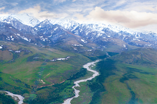 Aerial view of Alaskan mountain range and river flowing through remote valley.