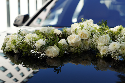 Flower wedding decoration on hood of a car - flower arrangement decoration. High quality photo