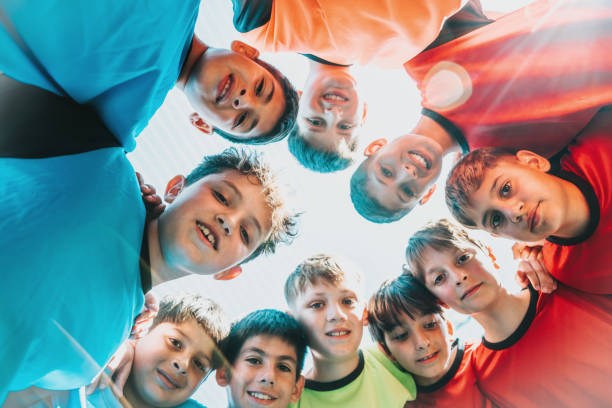 istock boy soccer team standing in circle and and looking down to camera 2075824746