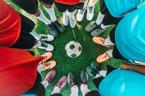 overhead view on boy soccer teams standing in circle around soccer ball on pitcho