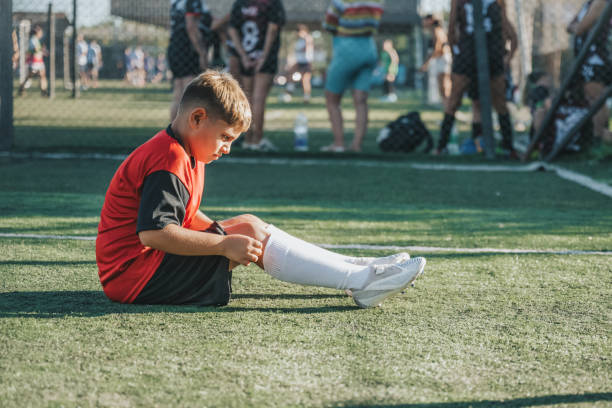 istock soccer boy rolling up socks  after match 2075828431