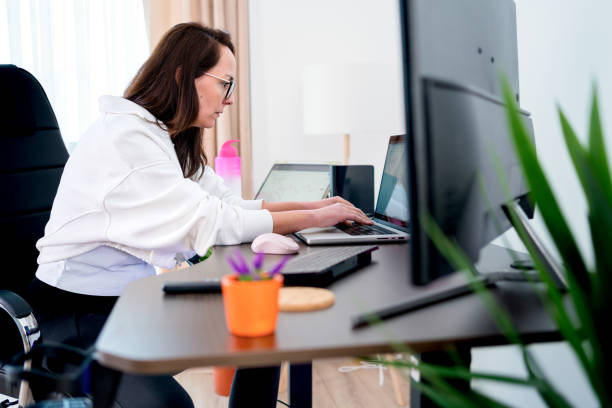 istock business woman sit indoors in  office using laptop computer 2075831068