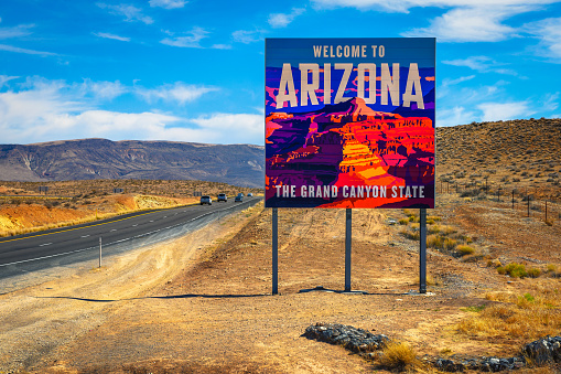 St. George, Utah, USA - June 12, 2022 : Welcome to Arizona State Sign with desert landscape situated along I-15 at the border with Utah.