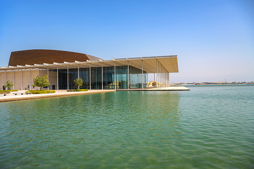 Manama, Bahrain - December 24, 2023 : Bahrain National Theater exterior with reflective pool and modern architecture. This is the third largest theatre in the Middle East.