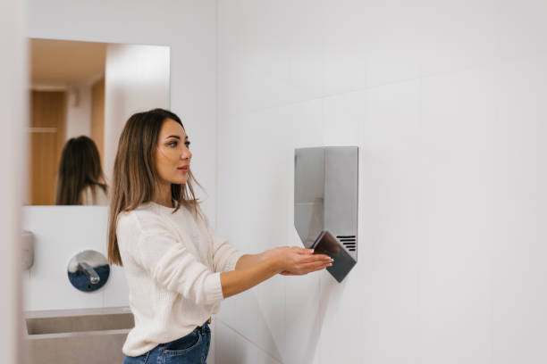 istock Caucasian woman dries her hands with hot water using a dryer 2075839574