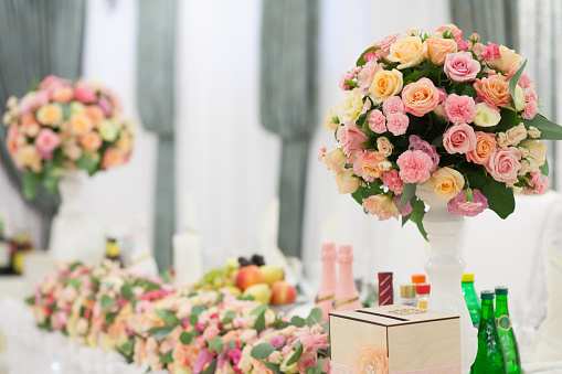 A bouquet of flowers in a glass vase on a wedding table