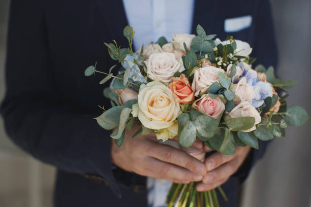 istock Stylish groom holding a tender pink wedding bouquet 2075875874