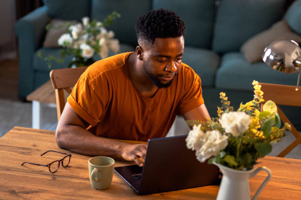 istock Young African American man sitting at home using laptop for video call. 2075877475