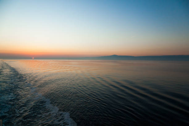 Sea and mountains horizon during sunset at dusk.