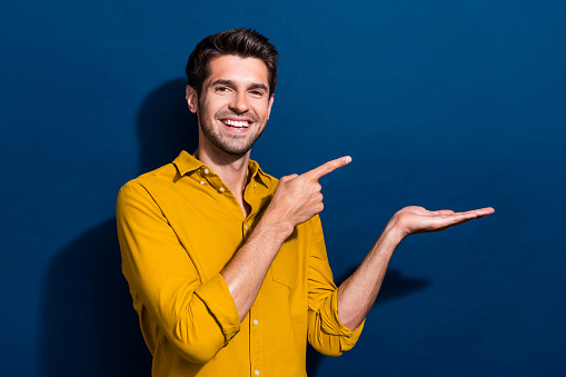 Young man pointing empty white background.