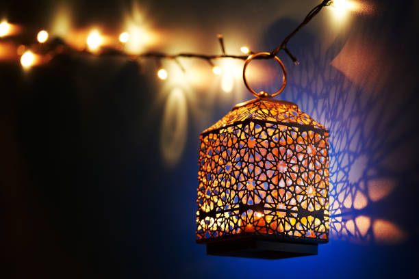 Ramadan decoration illuminated arabic lantern against blue background