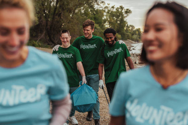 istock Volunteers in uniforms talking and carrying waste by the river 2075926649
