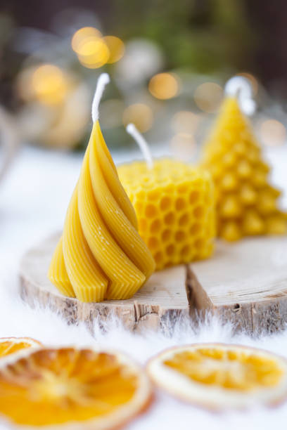 istock Bee wax candles on white background, Christmas lights in the back 2075935655