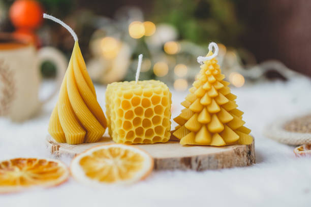 Bee wax candles on white background, Christmas lights in the back