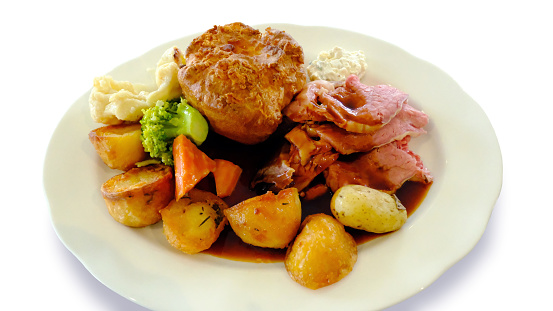 Traditional roast beef and vegetables cut out against a white background