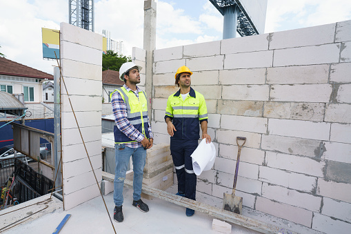 Male engineer and coworker discussing and checking work at site. Team builder worker at under construction