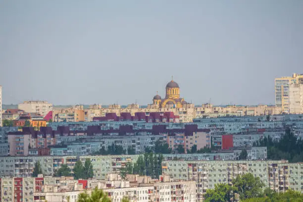 View from afar of Church of St. John of Kronstadt towering over residential district's buildings in Volgograd city, Russia in a sunny summer day. Copy space. Russian cityscape background.
