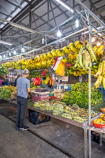 Chow Kit market, Kuala Lumpur, Malaysia - January 10th 2024:  Man standing in front of a market stall specialized in different kind of bananas