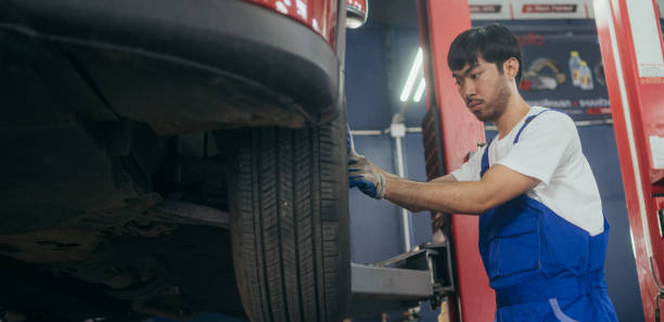 istock Automotive Asian mechanic worker checking at car tyre rubber condition needed for replacement. after service at auto repair shop concept 2076029956