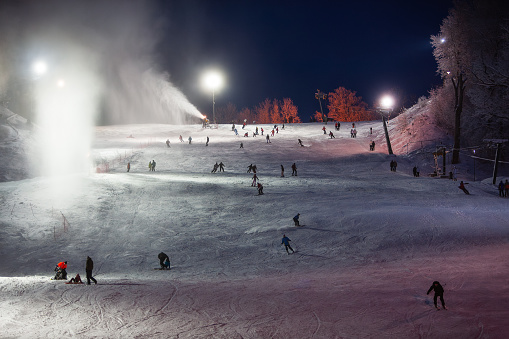 People are skiing on the Sigulda town track. Long exposure makes people unidentifiable