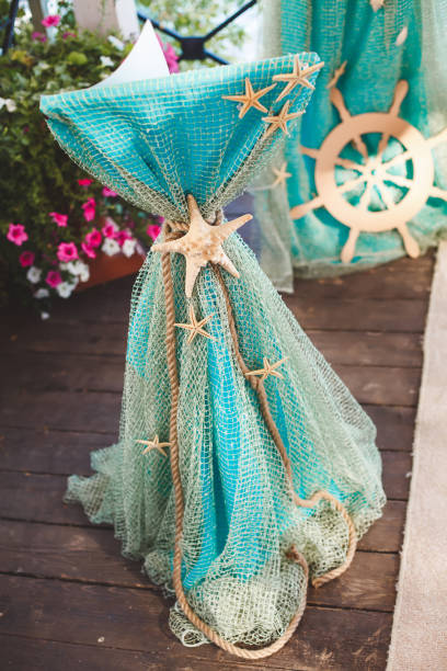 Table for painting on-site ceremony in a marine style. Decorated with nets, shells, anchor and helm