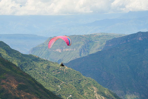 Paragliding in the Chicamocha Canyon area, Santander, Colombia. Paraglider flying enjoying the spectacular view of the surrounding mountain scenery.