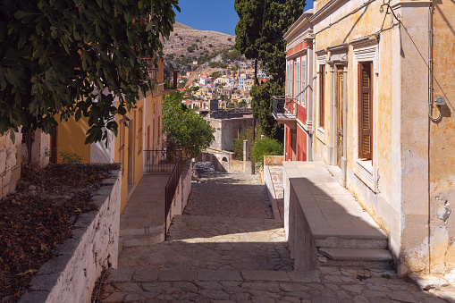 Narrow traditional street illuminated by the sun in the old village Symi. Rhodes. Greece.