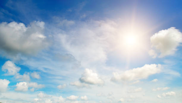 istock There are white cumulus clouds and a bright sun in the blue sky. 2076109662
