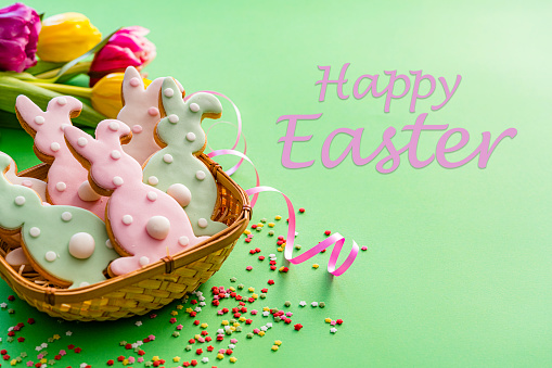Easter Bunny cookies greeting card on green background. High resolution 42Mp studio digital capture taken with SONY A7rII and Zeiss Batis 40mm F2.0 CF lens