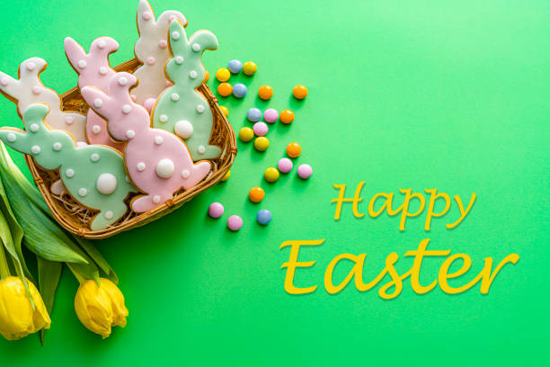 Easter Bunny cookies greeting card on green background. High resolution 42Mp studio digital capture taken with SONY A7rII and Zeiss Batis 40mm F2.0 CF lens