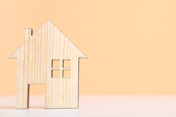 istock Wooden house model on beige background 2076139070