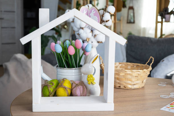 istock Tiny house of cozy home with Easter decor with rabbit and eggs on table of kitchen. Building, design, project, moving to new house, mortgage, insurance, rent and purchase real estate 2076140123