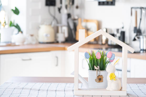 istock Key and tiny house of cozy home with Easter decor with rabbit and eggs on table of kitchen. Building, design, project, moving to new house, mortgage, insurance, rent and purchase real estate 2076140717