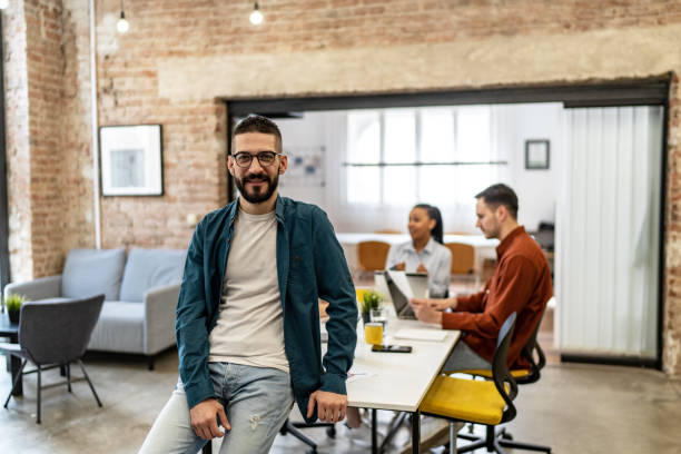 istock Confident and smiling handsome hipster man standing in the office 2076173677