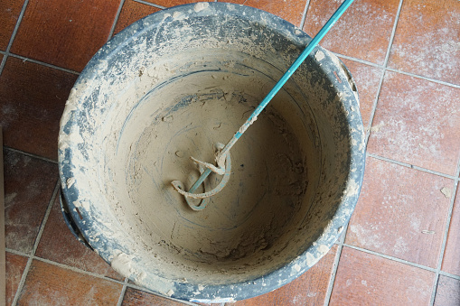 Bucket with whisk for mixing clay plaster