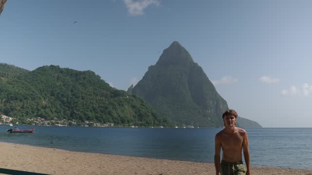 Slack lining near  Gros Piton and Petit Piton on St. Lucia from Soufriere Beach between palm trees