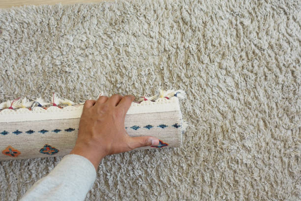 istock top view of men rolling out new rug. 2076218899