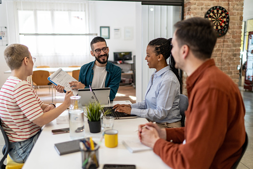 Close up of young people having business meeting in modern office