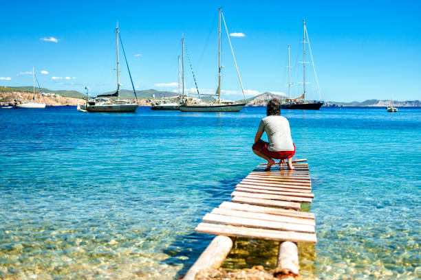 Man from behind in the water at Llentrisca Beach in Ibiza, Balearic Islands, Spain.