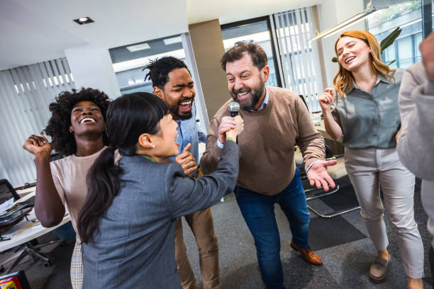 istock Multiethnic colleagues having karaoke party in the office. 2076285353