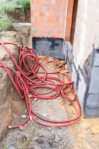 istock red corrugated pipes are prepared for supply electrical cable infrastructure installation. Construction site on private house building 2076297468