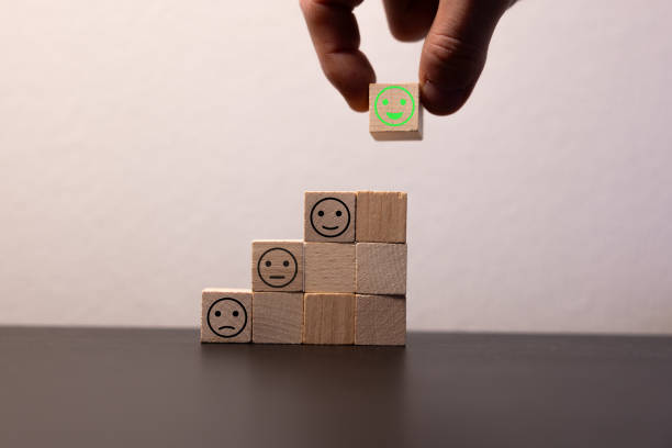 istock Close up top view customer hand choose smiley face on wood cube, Service rating, satisfaction concept. 2076318178