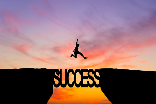 Man jump across text failure to success over cliff on sunset background. Failure Success concept. Business strategy.