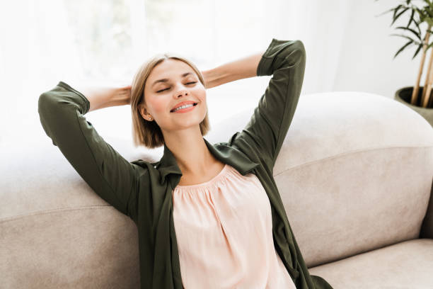 istock Serene caucasian female chilling on the couch leaning back stretching arms. 2076341453